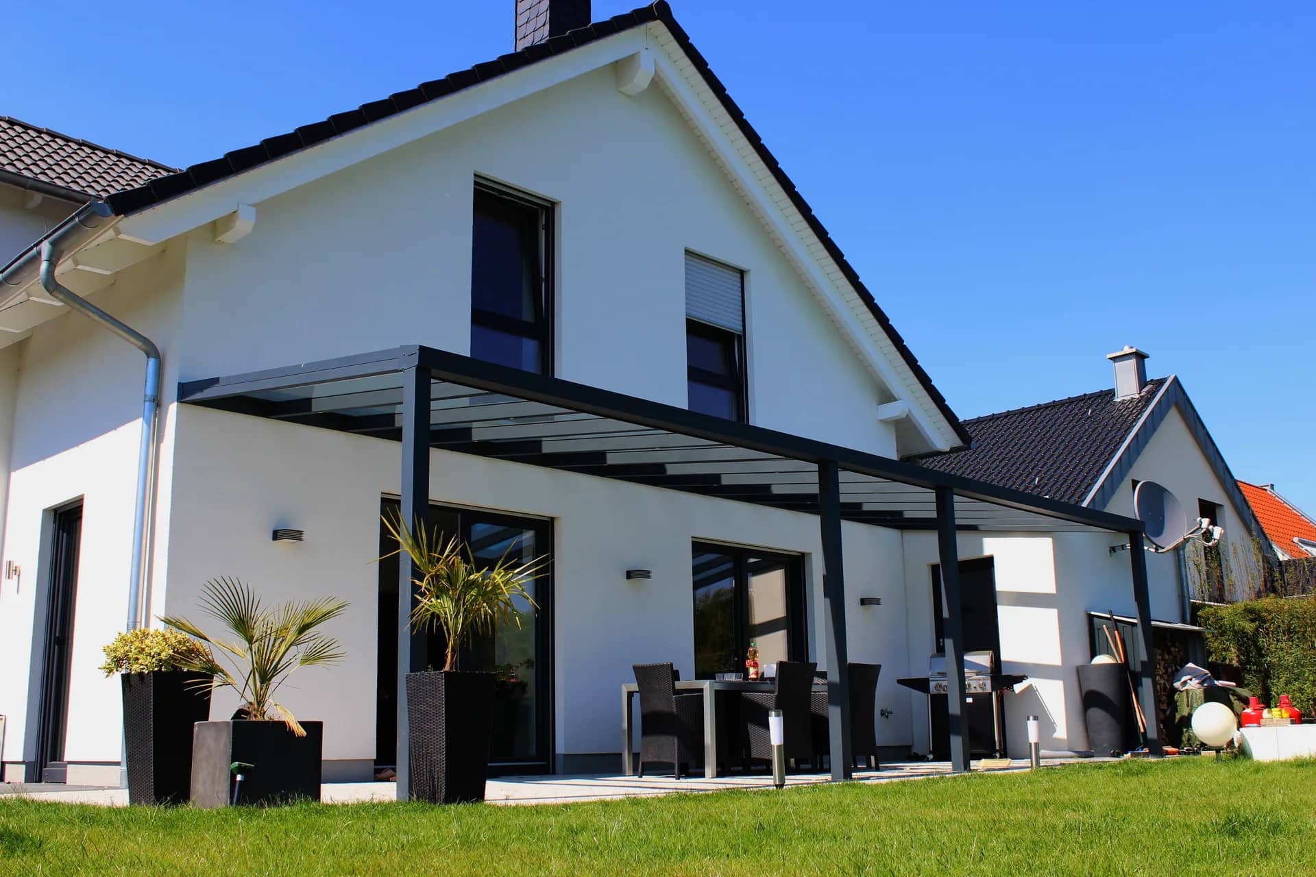An das Wohnhaus angebaute Aluminium-Terrassenüberdachung mit lichtdurchlässigem Dach