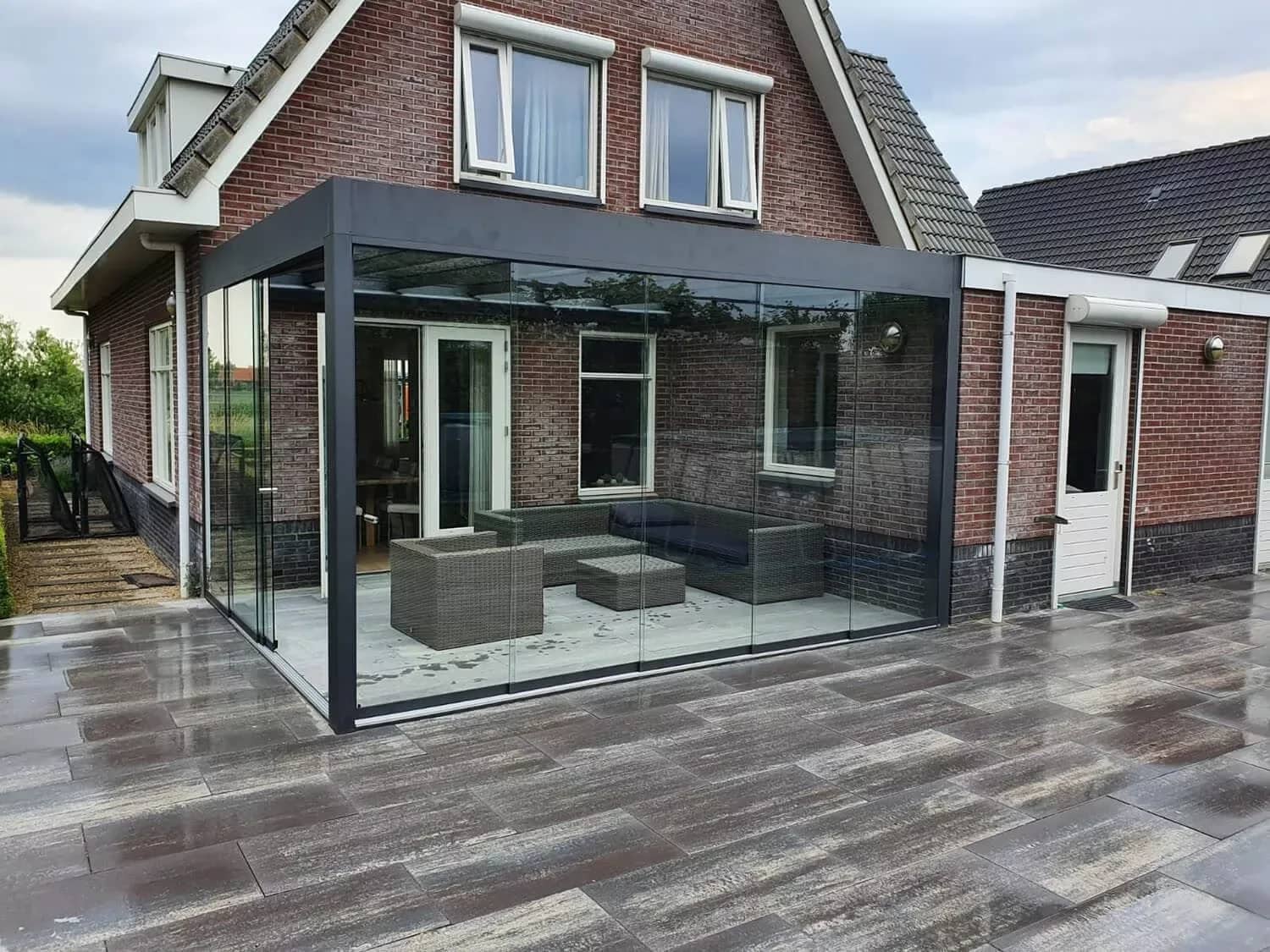 Rahmenlose Glas-Schiebeanlage als Windschutz an einer Terrassenüberdachung
