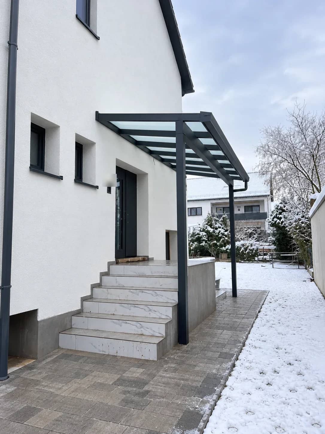 Eingangsüberdachung aus Aluminium mit lichtdurchlässiger Eindeckung über dem Hauseingang
