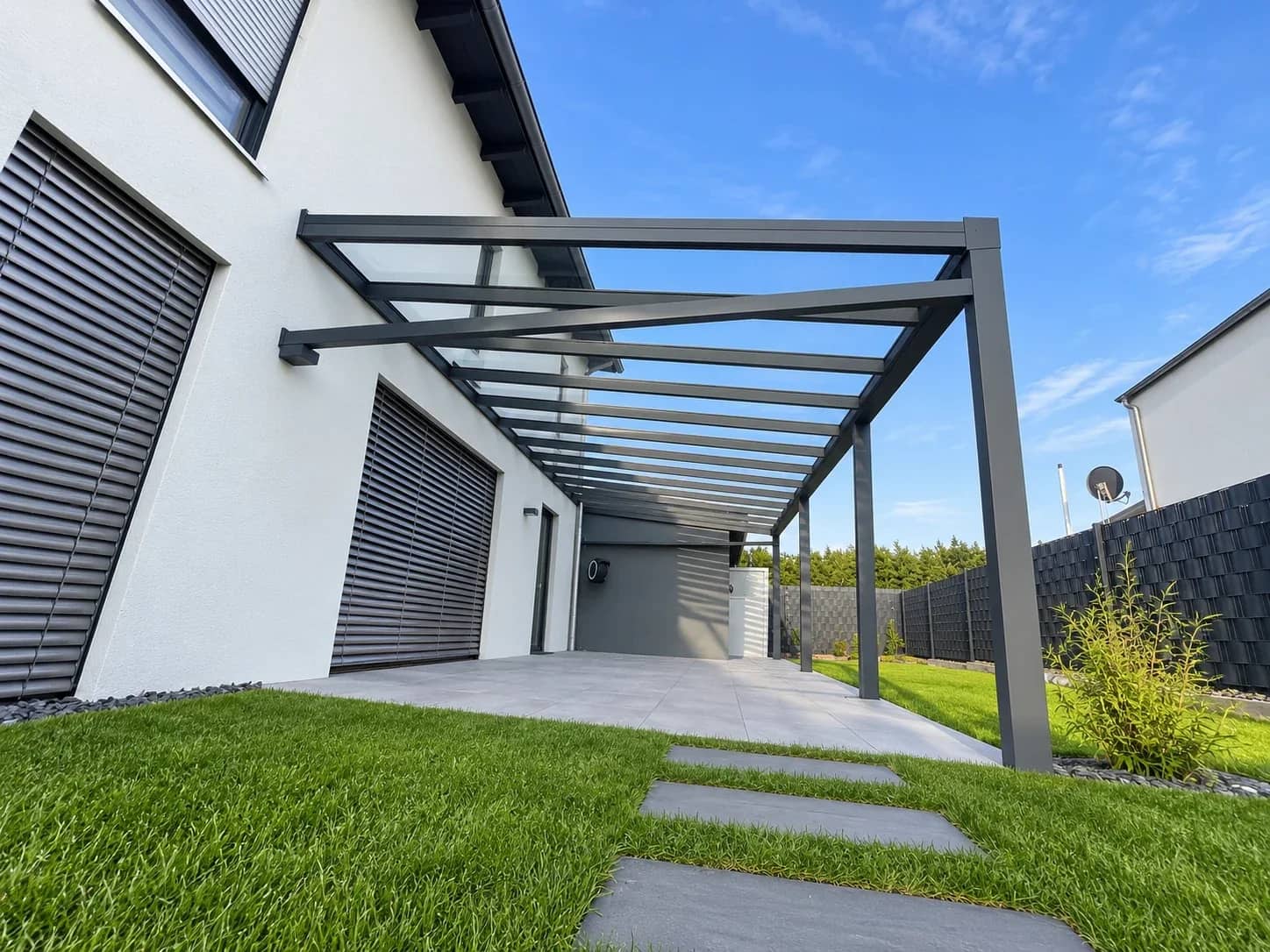 Terrassenüberdachung in Anthrazit mit lichtdurchlässiger Eindeckung, als Anbau an ein modernes Wohnhaus mit Terrasse in der Wetterau