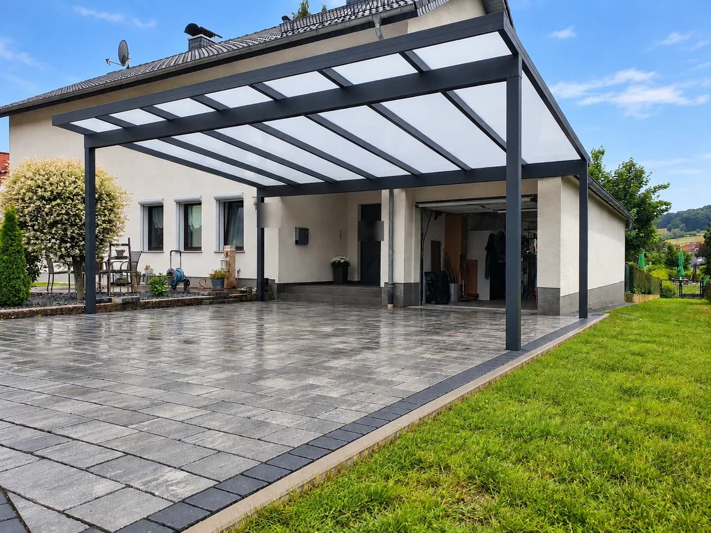 Solide ausgeführte anthrazitfarbene Terrassenüberdachung mit Glasdach