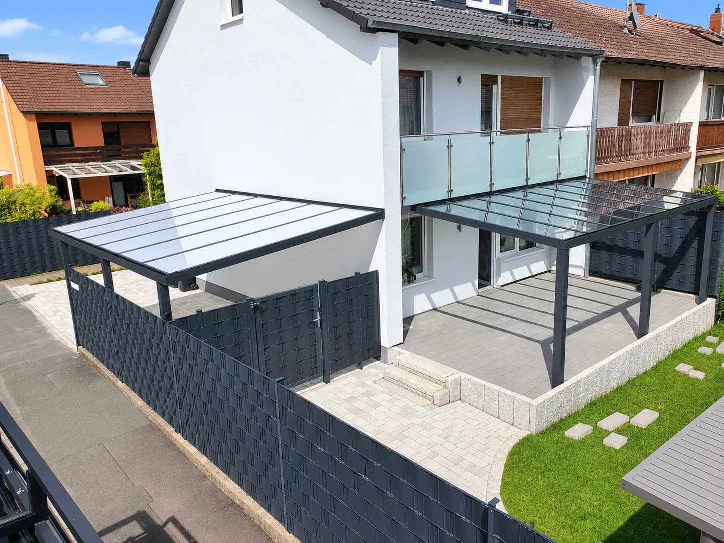Aluminium-Terrassenüberdachung in Anthrazit mit Glasdach und seitlichem Sichtschutzelement
