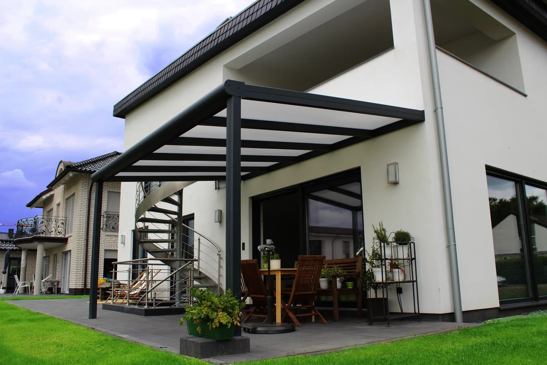Terrassenüberdachung aus Aluminium mit lichtdurchlässiger Eindeckung an einem Wohnhaus